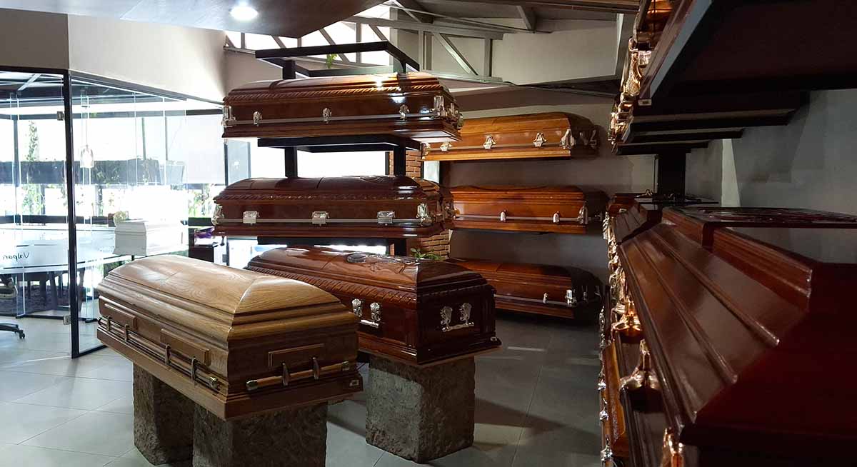 Exhibición de ataúdes en funeraria en Toluca con diferentes modelos disponibles.