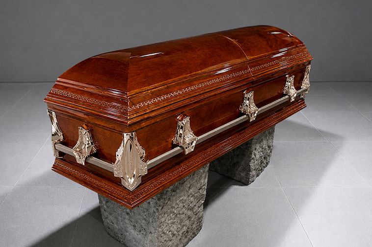 Ataúd Premium de madera con tapa curva, acabado brillante y herrajes metálicos, utilizado para homenajes de despedida en Funeraria Valparaíso.